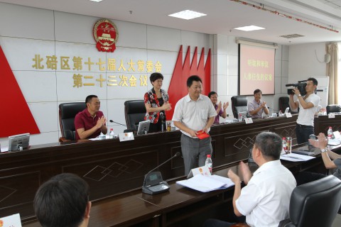 2015��8��26�ձ������ٿ���ʮ�߽��˴�ί��ڶ�ʮ���λ��飬ͼΪ������ͬ־����ϯ̨ǰ��ȡ����֤��